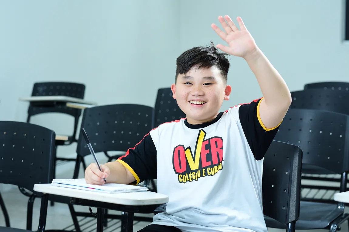 Aluna do Over sorrindo em sala de aula