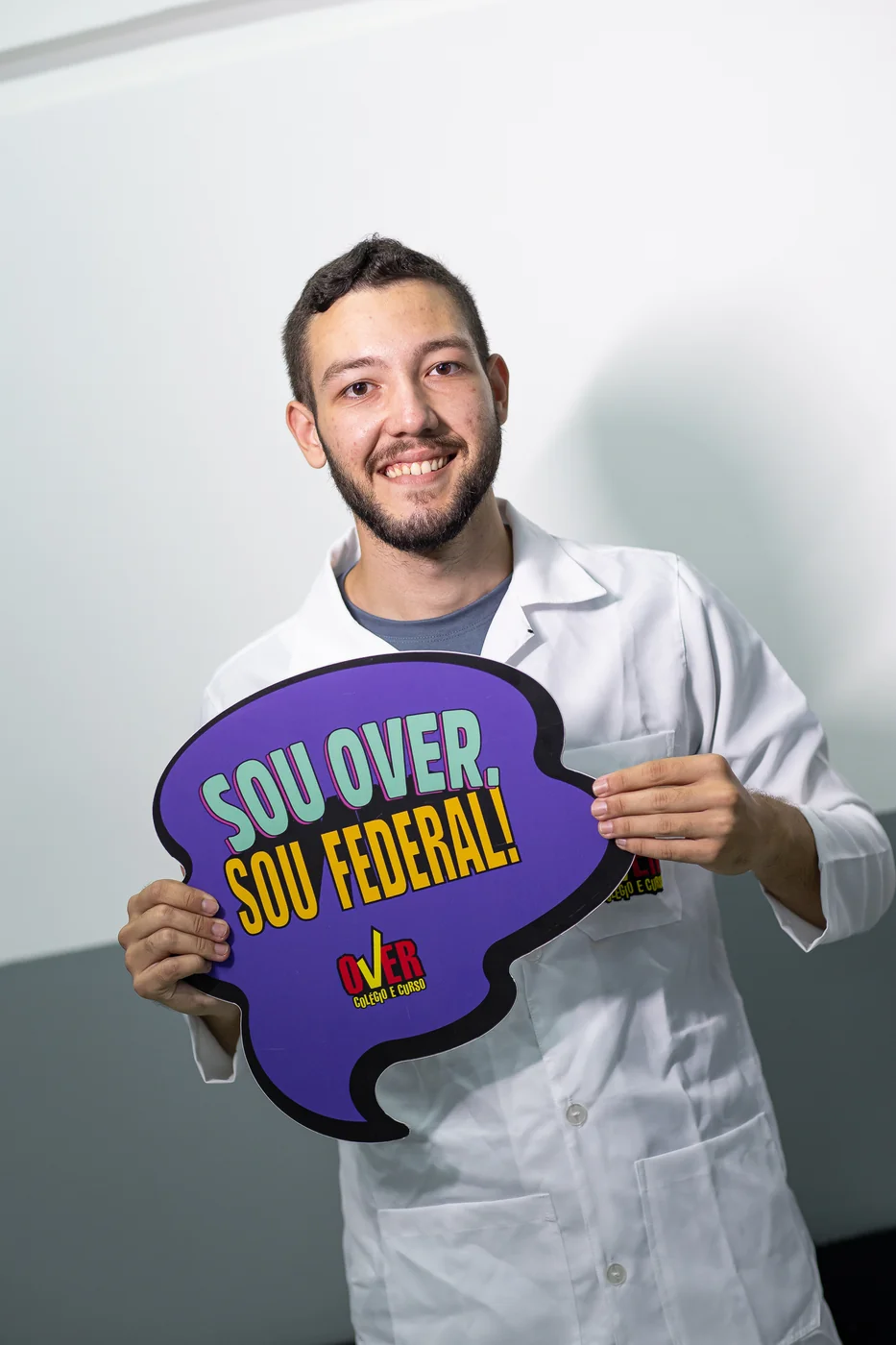 Aluno do Over segurando placa "Sou Over, sou federal!"